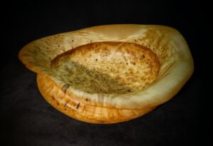 Handcrafted wooden bowl with a smooth finish, showcasing natural wood grain patterns. Perfect for serving salads, fruits, or as a decorative centerpiece
