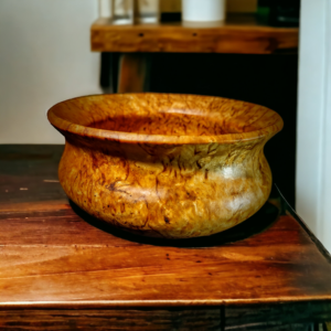 A close-up photo of a beautifully handcrafted burl bowl, showcasing intricate wood grain patterns and a polished finish