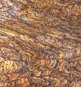 Close-up view of a handcrafted item featuring the intricate patterns and rich colors of rare Buckeye Burl wood, showcasing its unique and natural beauty in artisanal design.